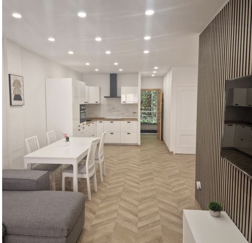 Open woonkeuken met eiland en houten wand