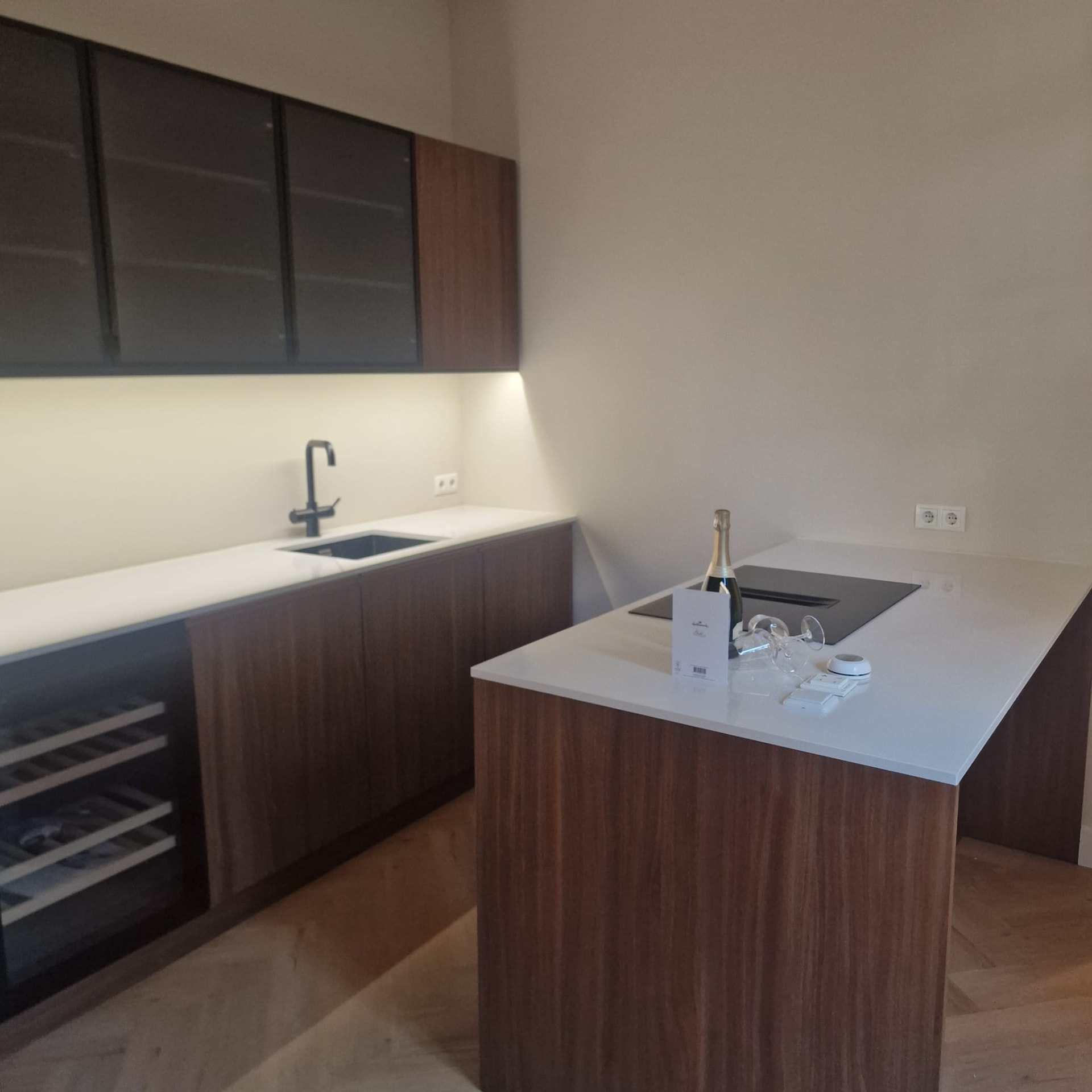Moderne keuken met walnoot fronten en zwart glas