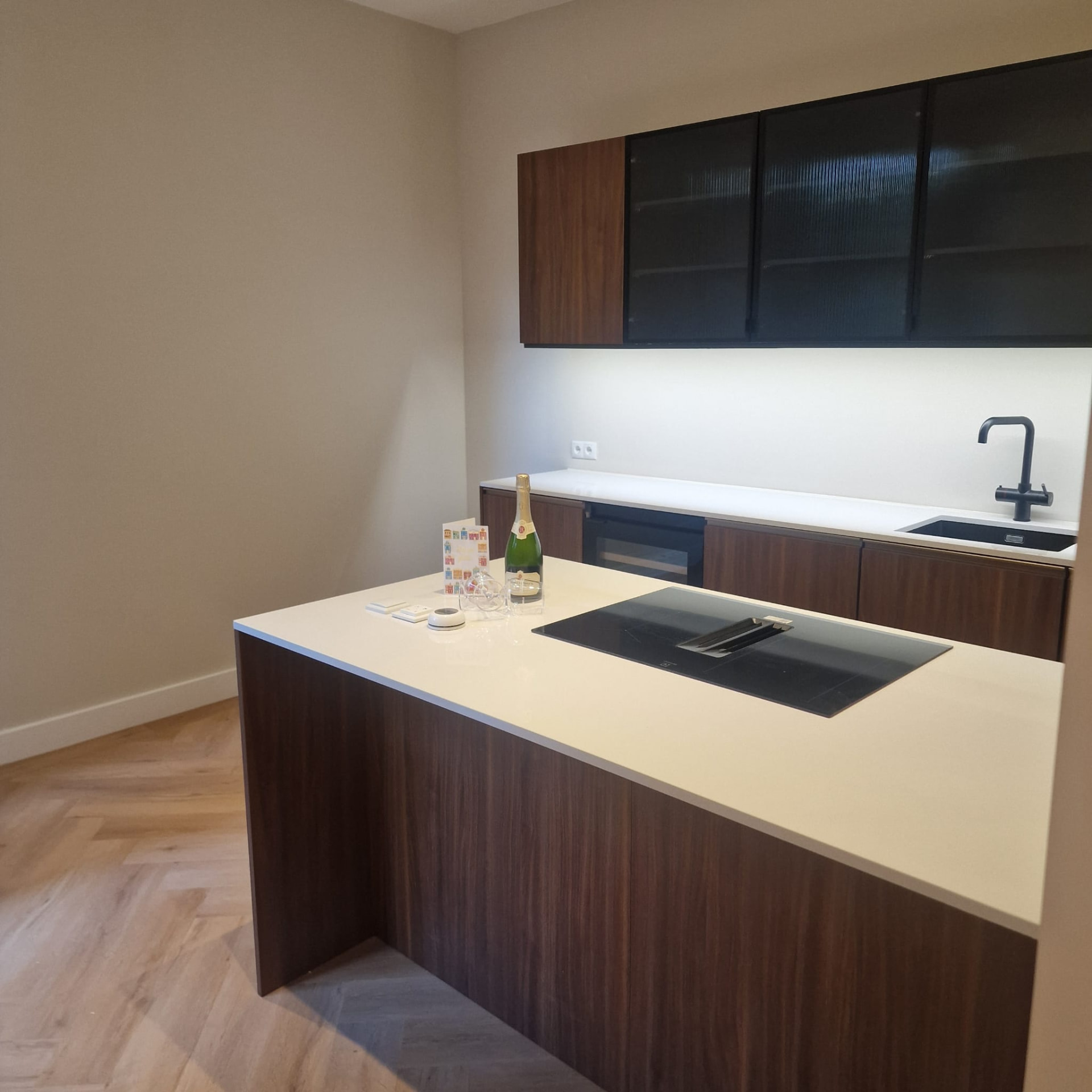 Keukeneiland met wit werkblad en houten kasten